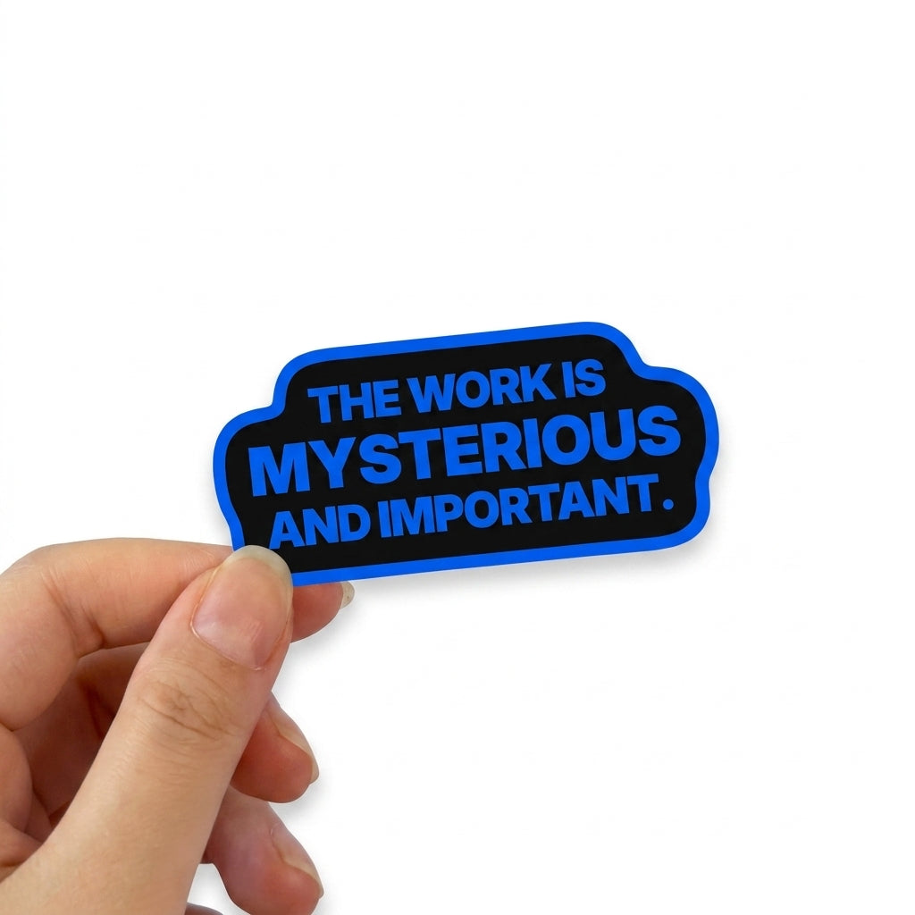 Black corporate humor sticker with blue text reading “The work is mysterious and important.”