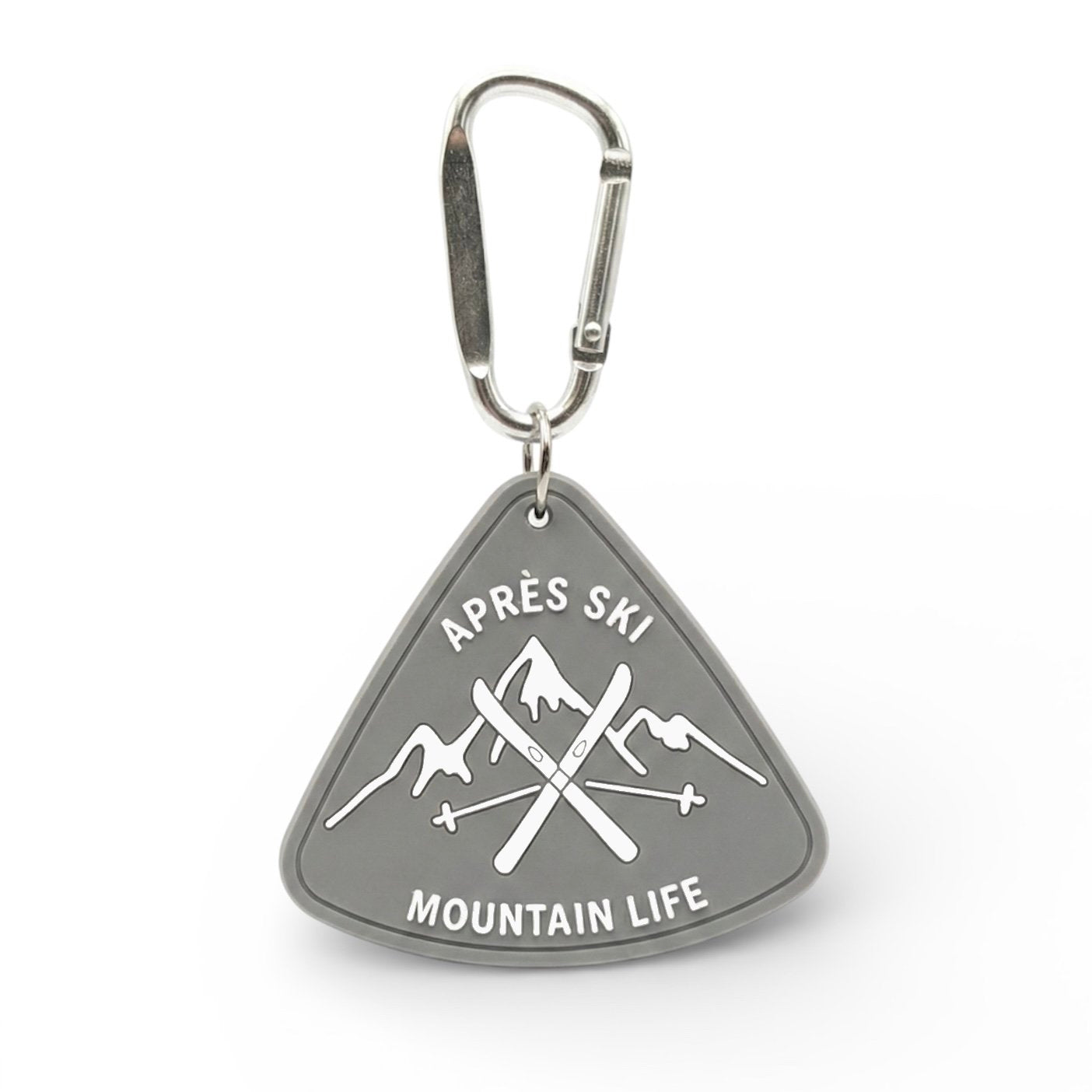 Sunday Said Après Ski bag charm. Grey triangular rubber keychain featuring crossed skis and Mountain Life text. Perfect winter sport gift for skiers.