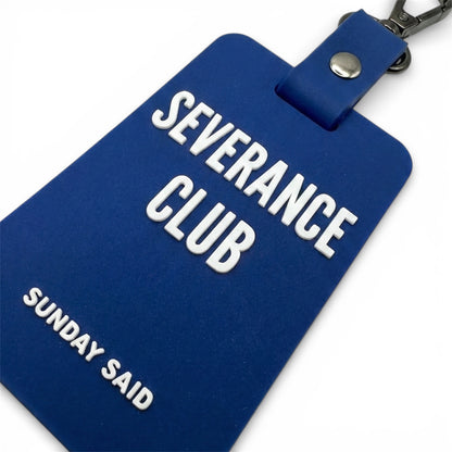Close up of 3D raised white lettering on blue rubber charm. High quality silicone texture detail showing Severance Club text. Durable bag accessory.