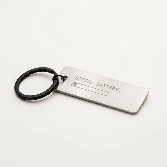 Metal keychain with 'Social Battery' text on a white background